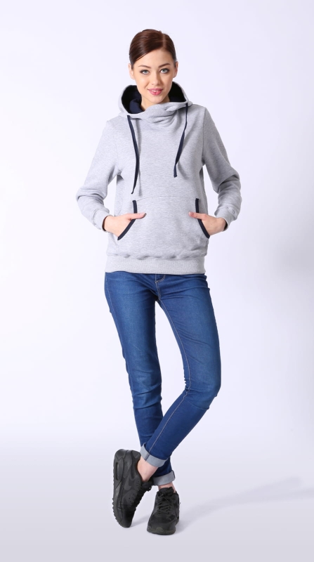 Modelka w bluzie dresowej fason VBL-37 w kolorze jasnego melanżu w stylizacji z granatowymi jeansami, bluza z kapturem i wysoką stójką, wkładana przez głowę, kieszeń typu kangurka, rękawy zakończone ściągaczem, ściągacz u dołu bluzy, bluza bawełniana.jpg