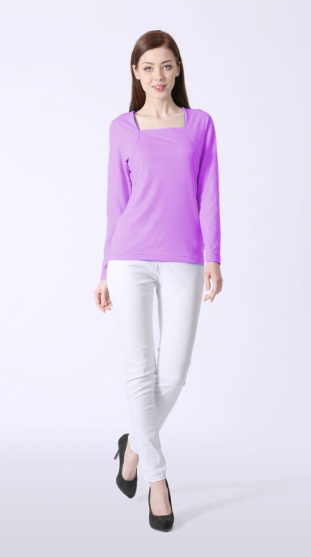 Modelka w bluzce damskiej bawełnianej z długim rękawem w kolorze lawendowym, fason VKDRd-25, dekolt karo, efekt bolerka, delikatnie taliowana, w stylizacji z białymi spodniami.jpg