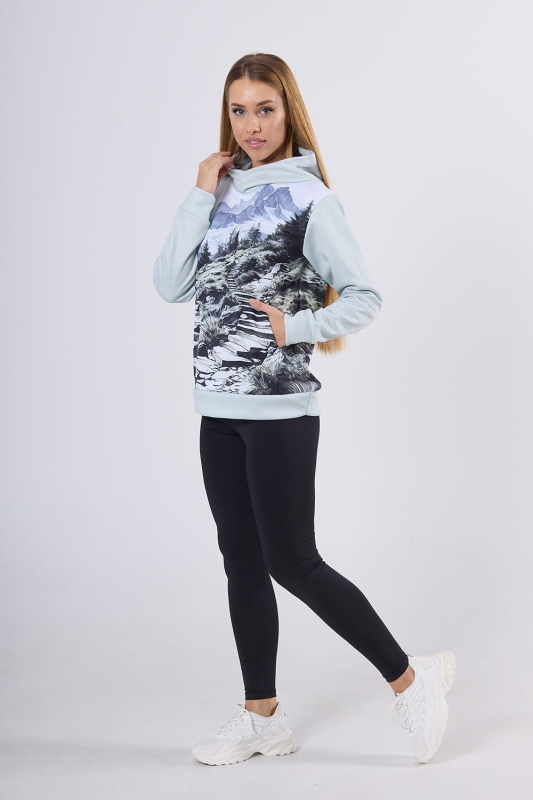 Modelka w bluzie hoodie fason VBL-46 z grafiką Mountains 0055, kaptur, kieszeń typu kangurka, grafika - szkic przedstawiający góry, las, strumyk, ścieżkę, w odcieniach szarości, bieli, błękitu.jpg