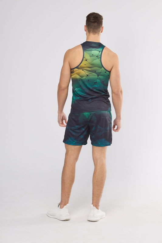 Model stojący tyłem w tank topie sportowym fason VKT-54 grafika sportowa nr 4001, tło tonalna zieleń z czarną siatką, w stylizacji z  czarnymi krótkimi spodenkami sportowymi.jpg