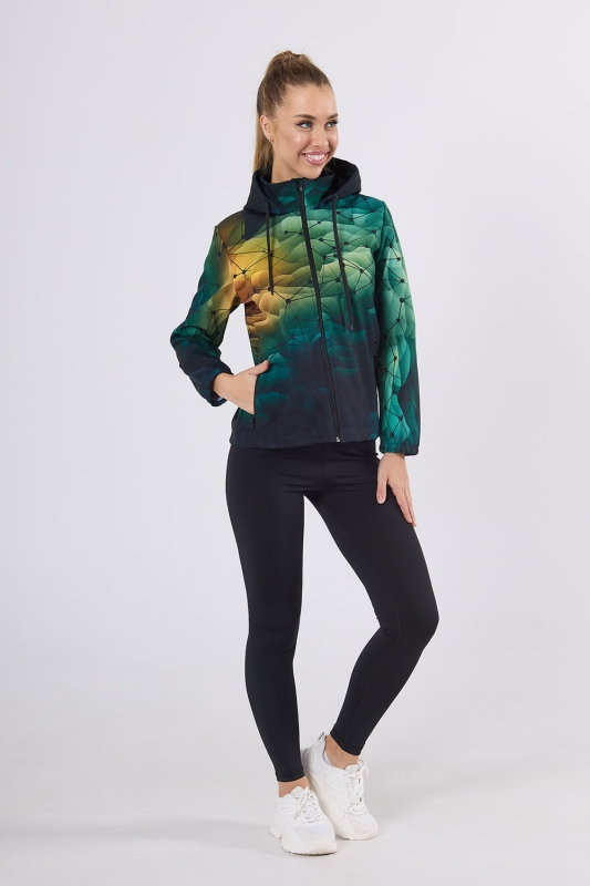 Modelka w softshellu VSOFTD-99 z grafiką 4001, w stylizacji z czarnymi leginsami, tło tonalne przejścia barwy zielonej z małym akceptem pomarańczowym, tło pokryte siatką geometryczną, kurtka z kapturem, dwie kieszenie zapinane na zamek, zamek główny.jpg