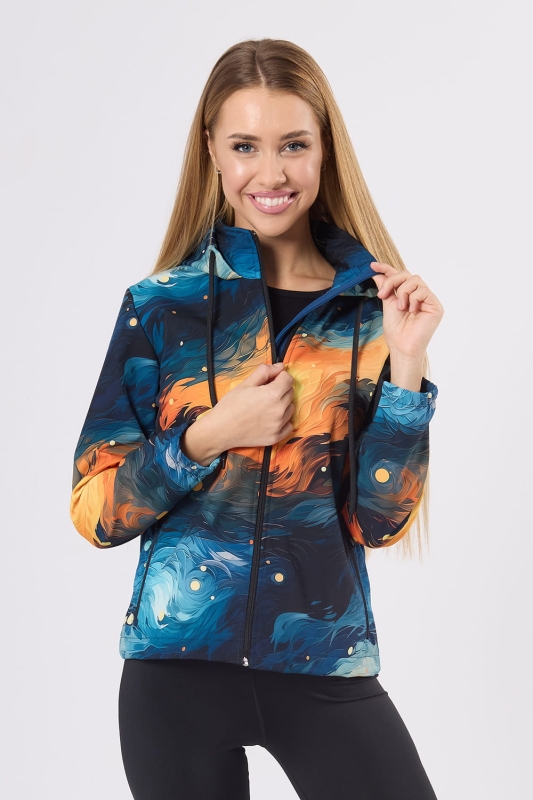 Modelka w kurtce softshell fason VSOFTD-99 z grafiką 4004 nadruk przypominający pociągnięcia pędzla w stylu Van Gogha, kolory dominujące niebieski, granatowy, pomarańczowy, żółty. Kurtka taliowana,  kaptur, zamek główny, dwie kieszenie z zamkami.jpg
