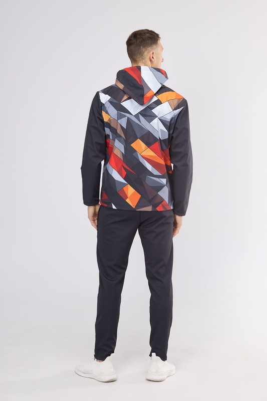 Model od tyłu w softshellu męskim fason VSOFTM-99 z grafiką 4000 w stylizacji z czarnymi spodniami, kurtka z  kapturem, stójka, rękawy czarne, korpus i kaptur w geometryczny wzór, kolory czarny, grafitowy, z dodatkiem czerwieni, pomarańczu i bieli.jpg