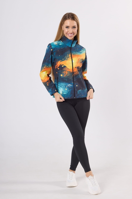 Modelka w kurtce softshell fason VSOFTD-98 z grafiką 4004 abstrakcyjny nadruk przypominający pociągnięcia pędzla w stylu Van Gogha, kolory dominujące niebieski, granatowy, pomarańczowy, żółty. Kurtka taliowana, zamek główny, dwie kieszenie z zamkami.jpg