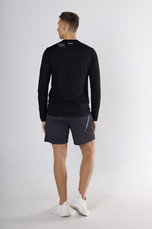 Model stojący tyłem w czarnym longsleeve fason VKDRM-1-sub na ramieniu zarys mapy świata.jpg