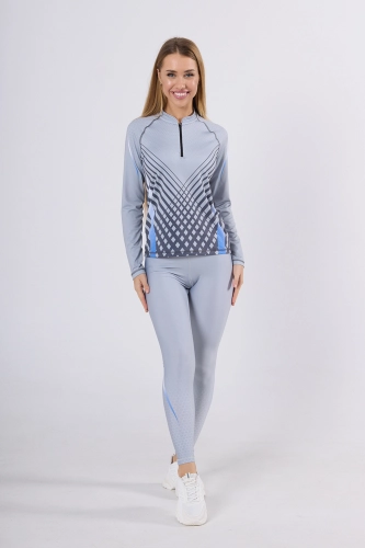 Modelka w longsleeve sportowy fason VKDRd-104 w barwy jasno szare z geometrycznymi delikatnymi akcentami, tworzą sportową stylizację z szarymi leginsami, grafika Sport szary 4009 Ventus.jpg