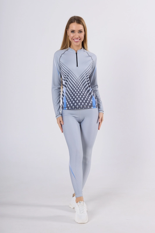 Modelka w longsleeve sportowy fason VKDRd-104 w barwy jasno szare z geometrycznymi delikatnymi akcentami, tworzą sportową stylizację z szarymi leginsami, grafika Sport szary 4009 Ventus.jpg