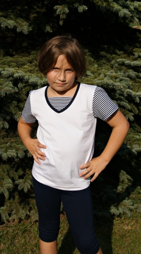 Dziewczynka w koszulce z krótkim rękawem, bawełnianej, koszulka biała, krótkie rękawy w wąskie paski biało-granatowe, wykończenie pod szyją granatową lamówką i wstawką ozdobną w paski biało-granatowe, stylizacja żeglarska, marynarska, fason VKD-51.JPG