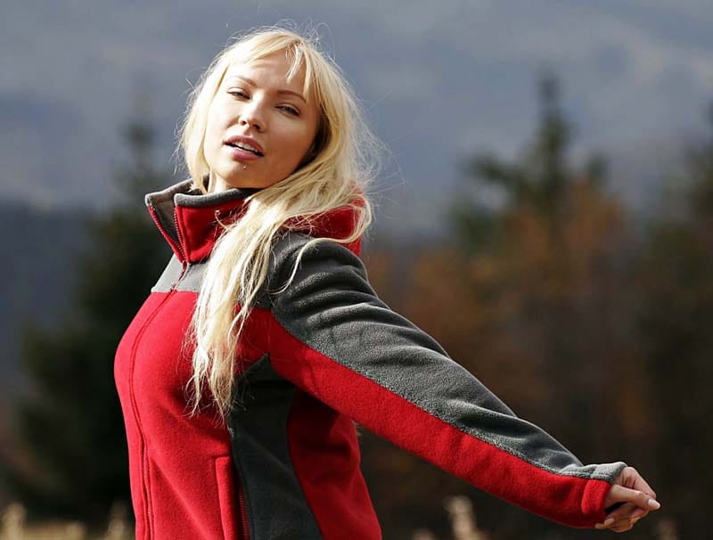 Zbliżenie na modelkę w polarze, modelka ma rozłożone ręce prezentując przeszycia na polarze i wstawki w kolorze szary,  fason polaru VPL-10, szare wstawki po bokach, na karku i rękawach.jpg